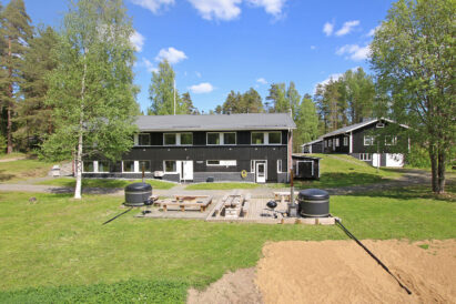 Evon Suuri Huvila kesäasussaan. Etualalla rantaterassi ja 2 kylpypaljua.