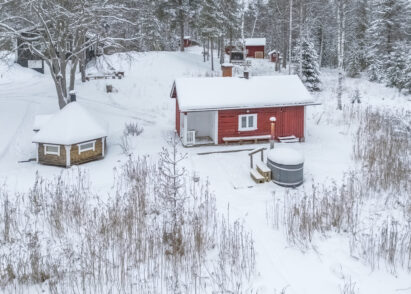 Evon Suuren Huvilan perinteisen rantasaunan vieressä on kylpypalju ja grillikota.