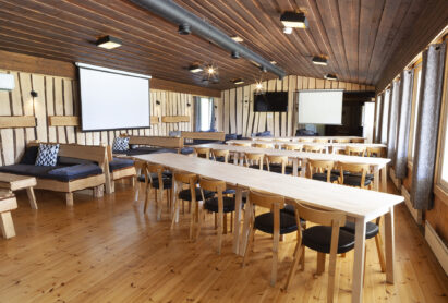 Aulangon Suuren Huvilan pääsalin pöydät voidaan järjestää monipuolisesti erilaisiin ruokailu- ja kokousasetelmiin. Salin sivu- ja päätyseinällä on myös alas laskettavat valkokankaat.