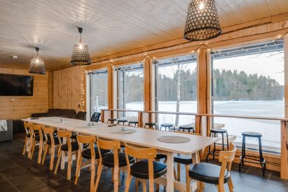 Aulangon Rantahuvilan pääsali. Etualalla ruokapöytä ja maisemabaaritiski.