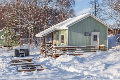 Aulangon Rantalan rantasaunan edessä on erähenkinen tulipaikka ja puulämmitteinen kylpypalju.