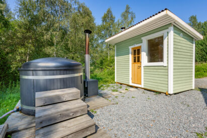 Aulangon Rantapiilon puulämmitteinen pihasauna kylpypaljun ja järvinäkymän äärellä.