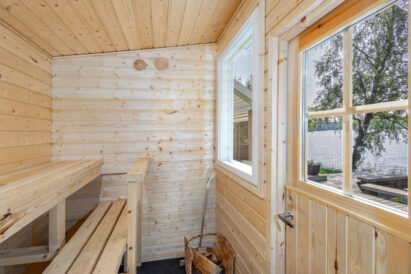 Aulangon Rantapiilon puulämmitteinen pihasauna kylpypaljun ja järvinäkymän äärellä.