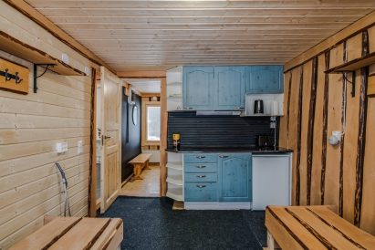 Aulangon Suuren Huvilan rantasaunan pukuhuone, jossa on myös keittiötaso ja jääkaappi.