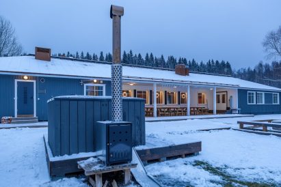 Aulangon Suuren Huvilan etupiha talvisena iltana. Etualalla puulämmitteinen kylpypalju.