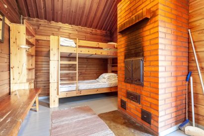 Evon Ruuhijärven isomman rantasaunan pukuhuoneessa on 2 makuupaikan kerrossänky ja järeä tiilinen uuni.