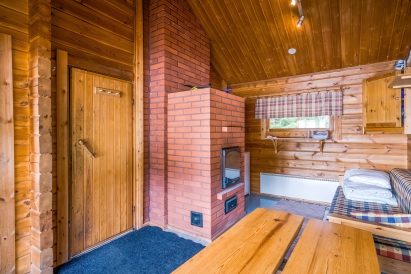 Evon Syväjärven saunarakennuksen pukuhuoneessa on tunnelmallinen tiiliuuni. Nurkassa on myös jääkaappi saunajuomille. Levitettävää sohvaa voidaan käyttää 1-2 hengen vuoteena.
