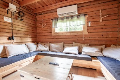 Evon Erähuvilan pääsalin toisen päädyn oleskelutilan u-sohvaryhmää voidaan käyttää myös lisävuoteina.