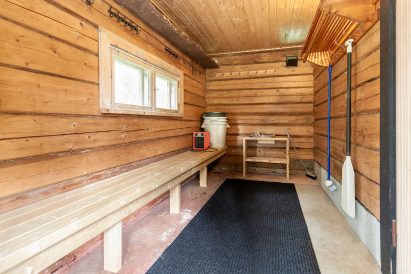 Evon Erähuvilan pihalla sijaitsevan perinteisen puulämmitteisen saunan pukuhuone. Talviaikaan pukuhuoneeseen saadaan lämpöä sähköpuhaltimesta.