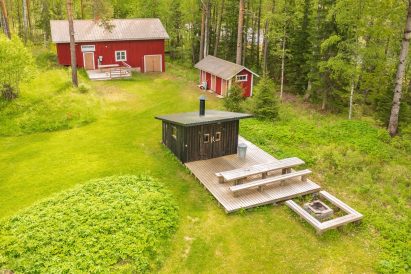 Evon Kaksikon alapihalla on erähenkisesti sisustettu grillikota, jonka edessä on erillinen ulkotulipaikka.