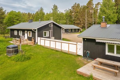 Evon Kaksikon pihanäkymä. Puulämmitteinen kylpypalju on huviloiden yhteinen ja aita tarjoaa näkösuojan Evon Suuren Huvilan suuntaan.