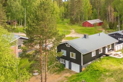 Evon Kaksikkoon kuuluvan Evon Rantahuvilan olohuoneen ikkunoista avautuu näkymä Kaitalammille. Taustalla punainen Evon Eräliiteri.