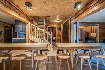 Hämeen Privaatin salin pöydät ovat kätevästi avokeittiön jatkeena. Portaat johtavat yläkerran majoitustiloihin.