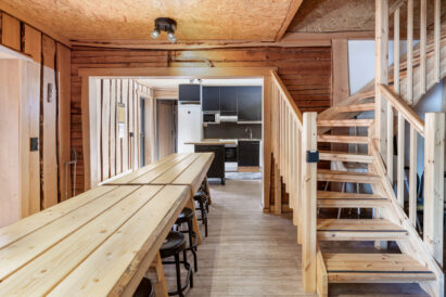 Hämeen Privaatin salin pöydät ovat kätevästi avokeittiön jatkeena. Portaat johtavat yläkerran majoitustiloihin.