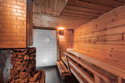 Lopen Erähuvilan Minihuvilan puulämmitteinen sauna, jonka takanurkassa on suihkutila.