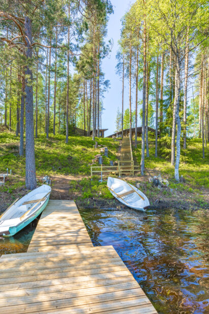 Lopen Luksuksen laituri ja soutuveneet idyllisen Kaartjärven rannalla.