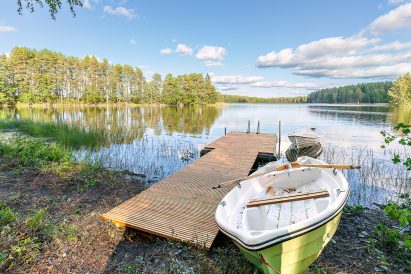 Lopen Luksuksen laituri ja soutuveneet idyllisen Kaartjärven rannalla.