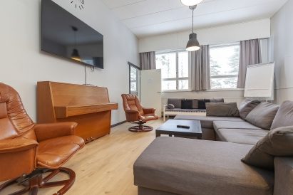 Räyskälän Suuren Huvilan pääsalissa on kaksi laajakuvatelevisiota ja piano. Sohvat soveltuvat myös lisävuoteiksi.