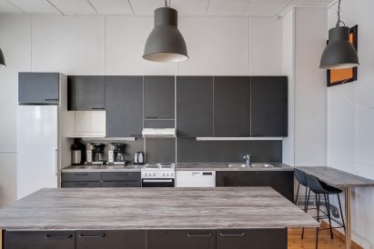 Räyskälän Suuren Huvilan pääsalin päädyssä oleva avokeittiö on kattavasti varustettu ja tarjoaa hyvän tilan myös omatoimiseen kokkailuun hyvässä seurassa.